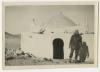Charles "Chuck" O'Neill in front of a small building in the desert. Recto