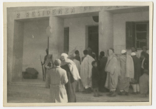 Crowd in front of a public building. Recto