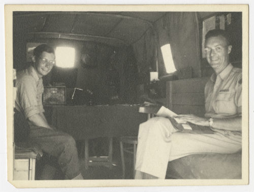 Erwin "Pat" Fiero and David "Dave" Briggs inside the trailer headquarters. Recto