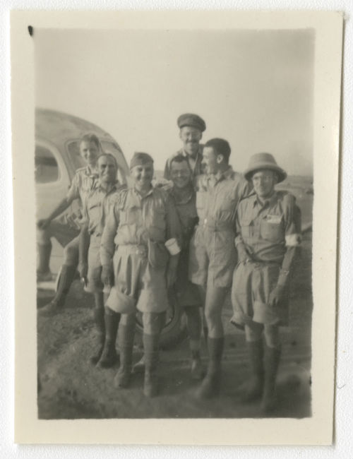 Seven men in uniform in the desert