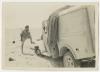 Wayne McMeekan with ambulance damaged by a land mine. Recto