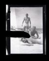 Dave Hyatt (standing) with two men on a beach