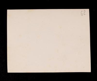 Group of unidentified individuals outside, with vehicles in the background. Verso.